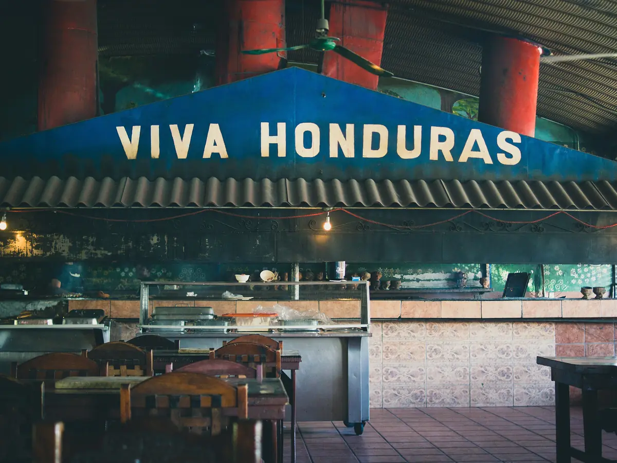 Cocina abierta de un restaurante hondureño bajo el rótulo «Viva Honduras»